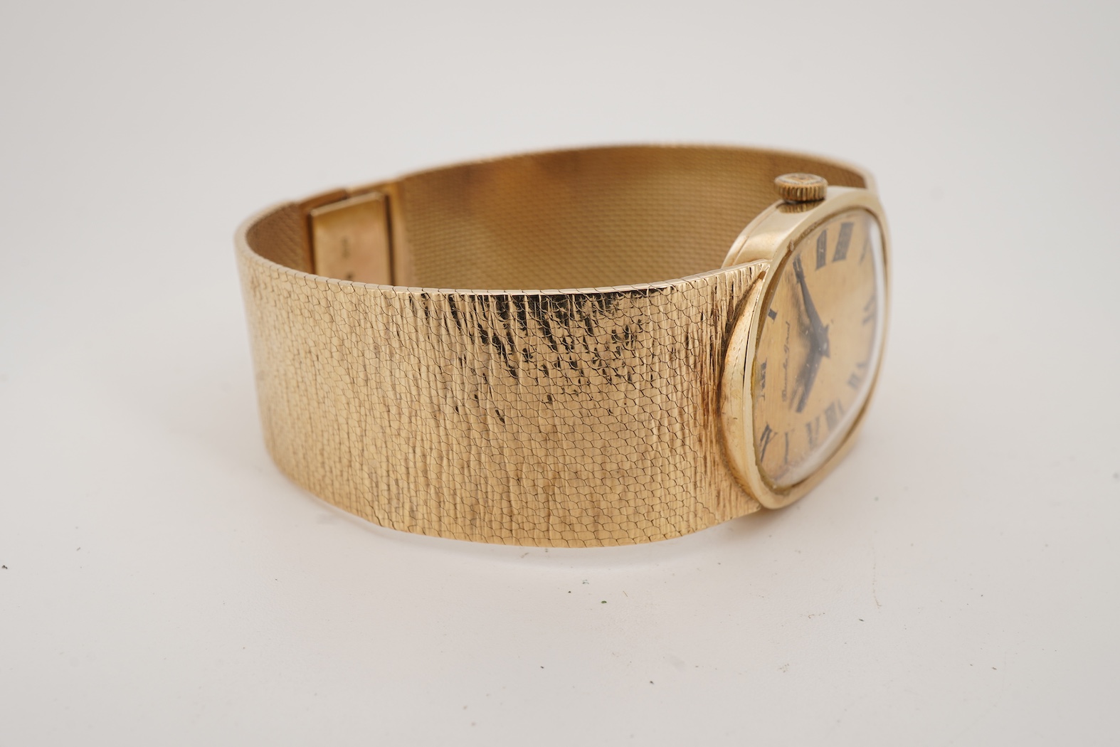 A gentleman's early 1970's 9ct gold Bueche Girod manual wind dress wrist watch, on an integral 9ct gold bark effect bracelet